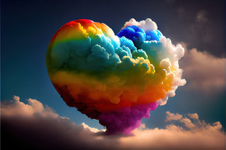 Rainbow coloured heart formed from clouds. with white shaded clouds all around, on a blue sky background.