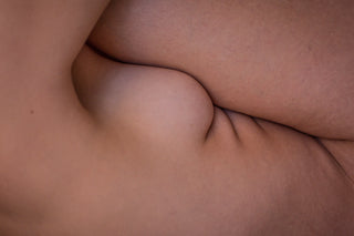 Close-up abstract composition of intertwined nude human skin and body folds